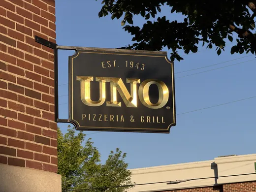 UNO Pizzeria and Grill projecting sign installed on a brick building